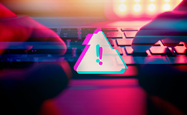 Tastiera PC e cartello di pericolo per simbolizzare la prevenzione delle truffe online
