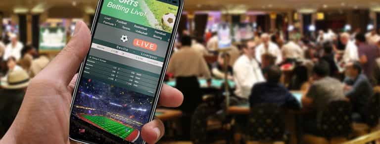 L'interno di un casinò e la schermata di uno smartphone con la piattaforma scommesse di un bookmaker online