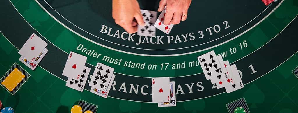 Tavolo del Blackjack con dealer che gira le carte.