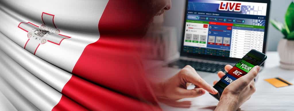 Persona che scommette online, pc con pagina scommesse e bandiera di Malta