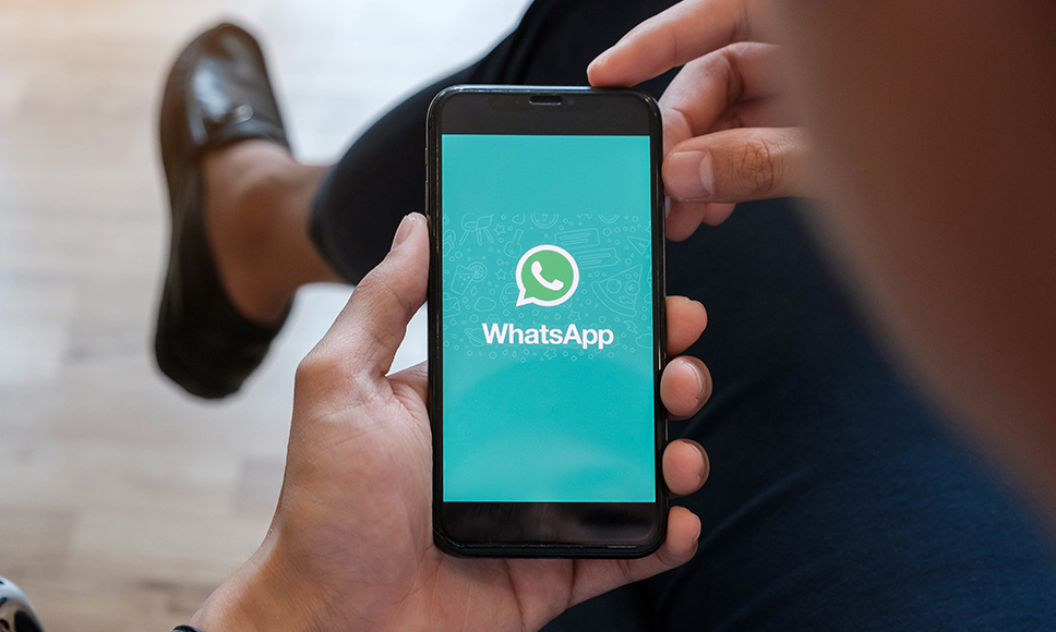 Un uomo che apre l’applicazione WhatsApp sul suo smartphone.