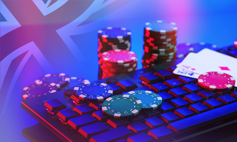 Tastiera di PC con fiches da casinò, carte da gioco e sfondo con la bandiera della Gran Bretagna. 
